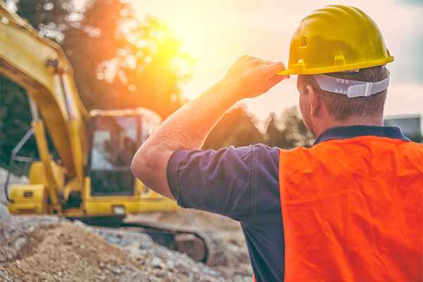 Construction worker supervising job at sunset