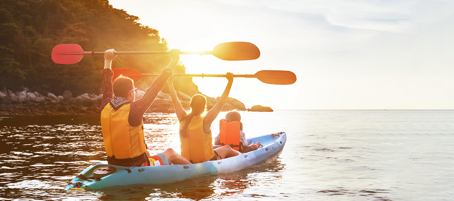 Family kayaking on a lake at sunset