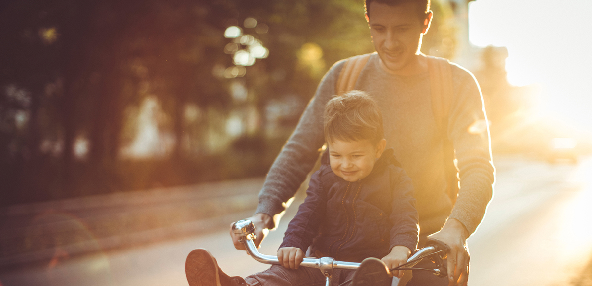 Father and Son riding bike at sunset