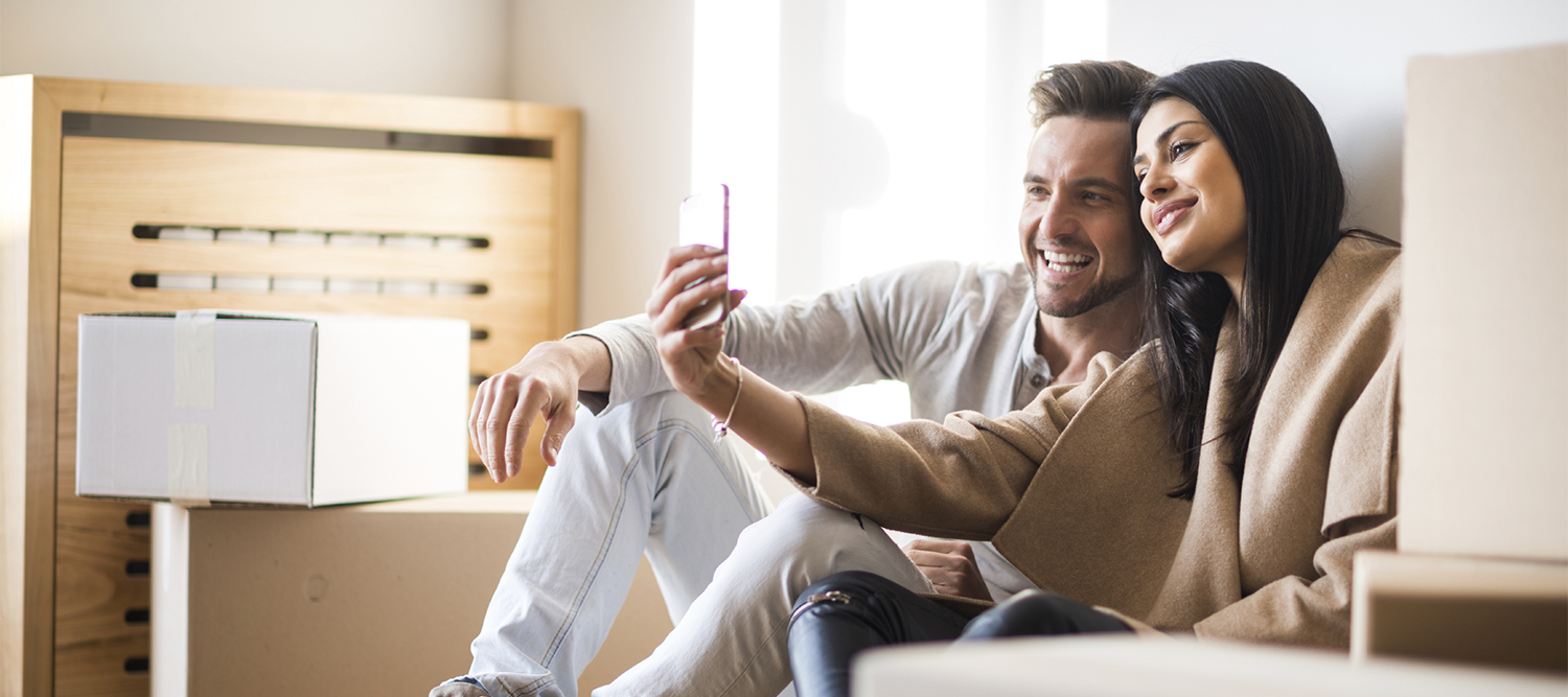 Happy couple taking a selfie in their new house