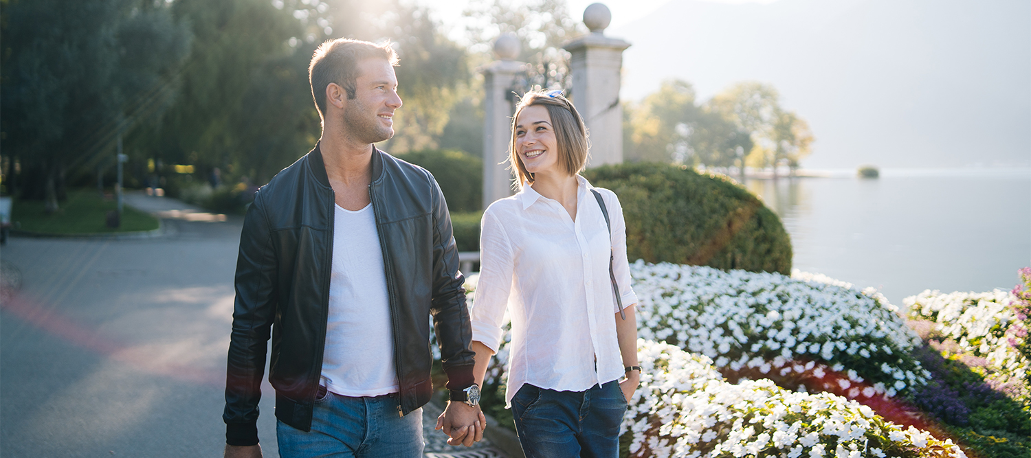 Happy couple walking along riverfront in spring