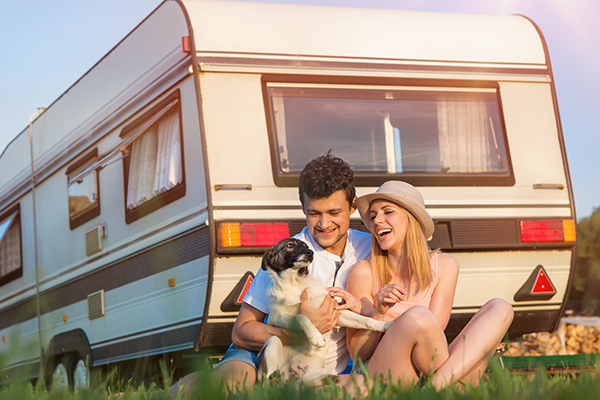 Happy couple with their dog camping in their RV