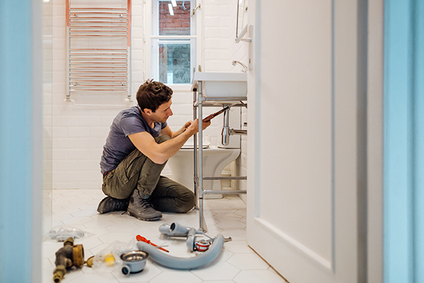 Man installing sink during home renovation