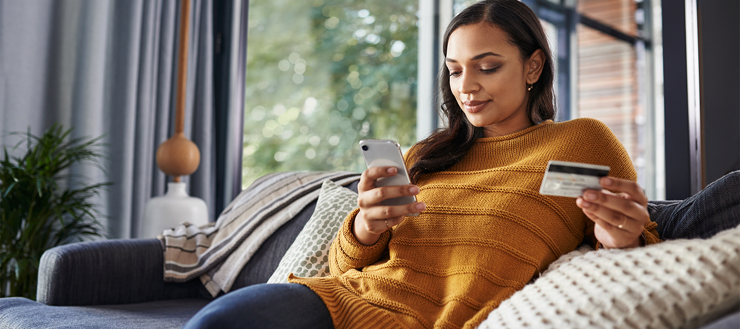 Woman banking on her mobile phone at home